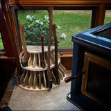Whiskey River Trading Liberty Bell Axe Bell for axe storage and organization next to the wood stove filled with axes