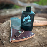 axe oil from walrus oil - a great way to protect your handle and head of your axe. The bottle of axe oil is placed next to the council tool camp carver